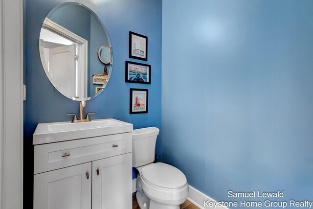 430 Union Ave NE Unit 303, Grand Rapids, MI 49503 - half bath featuring toilet, vanity, wood finished floors, and baseboards