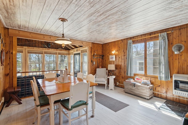 dining area featuring wood ceiling, heating unit, wood walls, and wood finished floors