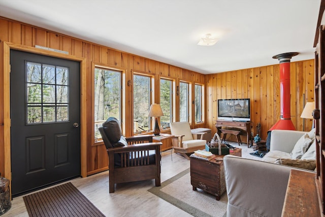 living room with light wood finished floors and wooden walls