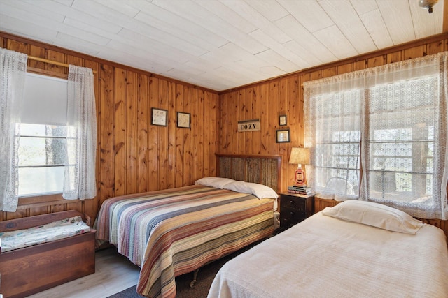 bedroom with wooden ceiling, wood finished floors, and wooden walls