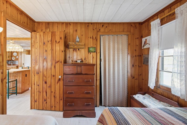 bedroom featuring wood ceiling, wood finished floors, wooden walls, and a closet