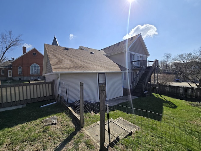 101 N Lewis St, Saline, MI 48176 - view of side of property with stairway, a lawn, a shingled roof, a fenced backyard, and a wooden deck