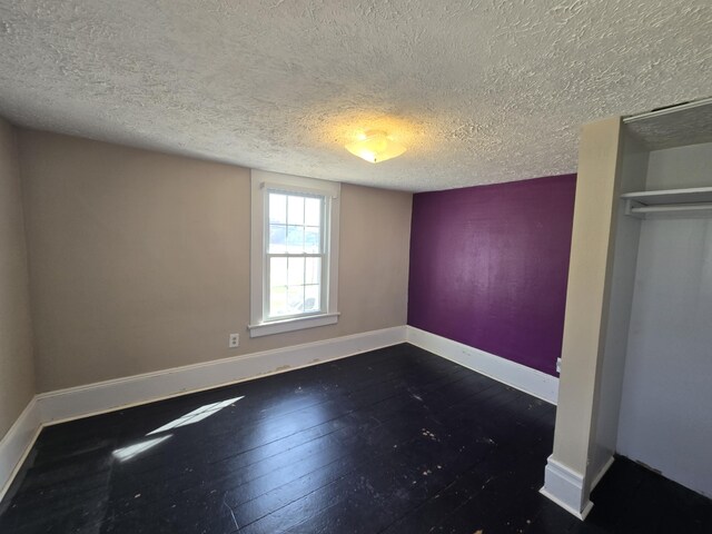 101 N Lewis St, Saline, MI 48176 - unfurnished bedroom featuring baseboards, a textured ceiling, and wood-type flooring