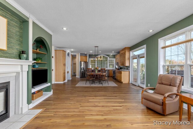 7174 Loma Linda Dr, Rockford, MI 49341 - dining area with a fireplace, light wood-type flooring, recessed lighting, built in shelves, and baseboards