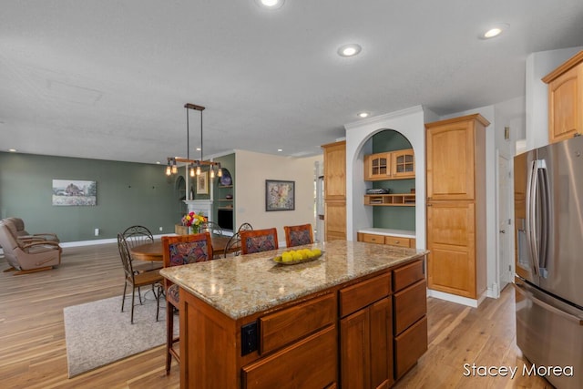 7174 Loma Linda Dr, Rockford, MI 49341 - kitchen featuring stainless steel fridge, open floor plan, light wood finished floors, a kitchen breakfast bar, and recessed lighting