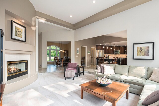 565 Hawksnest Dr, South Haven, MI 49090 - living area with a chandelier, a glass covered fireplace, a towering ceiling, and recessed lighting