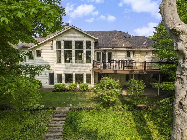 565 Hawksnest Dr, South Haven, MI 49090 - rear view of house featuring a wooden deck, a chimney, a yard, and a shingled roof