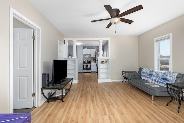 442 Emerald Ave NE, Grand Rapids, MI 49503 - living area featuring light wood-style flooring, a ceiling fan, baseboards, and decorative columns