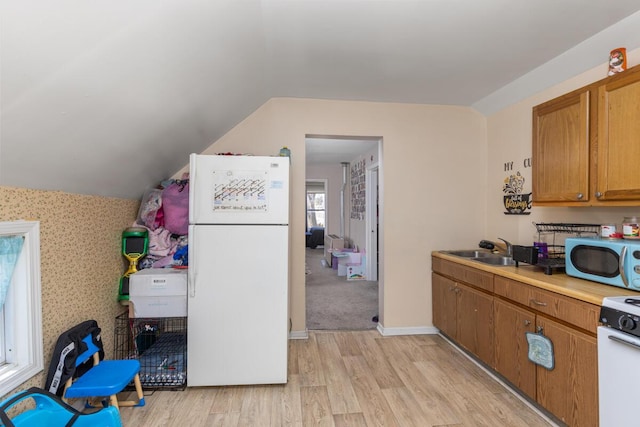 442 Emerald Ave NE, Grand Rapids, MI 49503 - kitchen featuring light wood-style flooring, a sink, vaulted ceiling, white appliances, and brown cabinetry