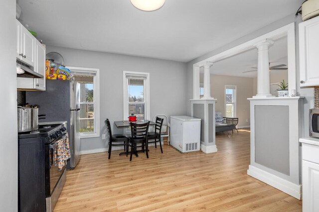 442 Emerald Ave NE, Grand Rapids, MI 49503 - kitchen with plenty of natural light, refrigerator, black gas range oven, and under cabinet range hood