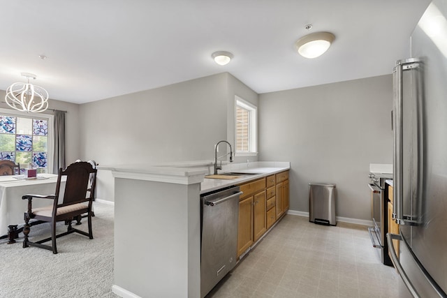 2777 Barclay Way, Ann Arbor, MI 48105 - kitchen with stainless steel appliances, brown cabinets, a peninsula, light countertops, and a chandelier