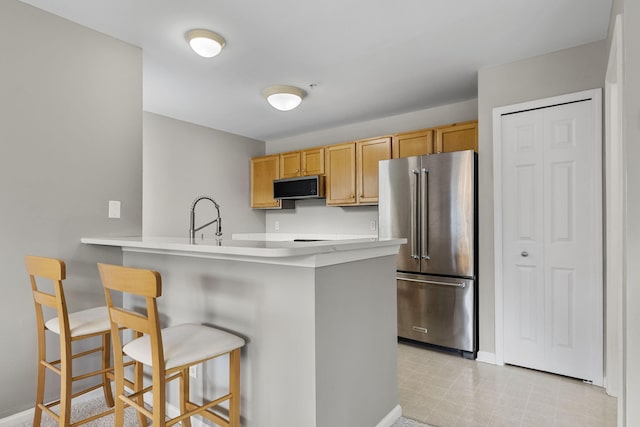 2777 Barclay Way, Ann Arbor, MI 48105 - kitchen with stainless steel appliances, a breakfast bar area, a peninsula, and light countertops