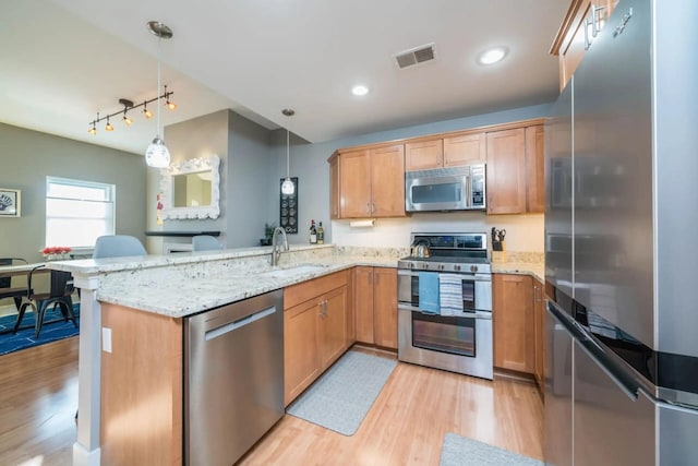 516 Williams St Unit 10, South Haven, MI 49090 - kitchen featuring stainless steel appliances, visible vents, light wood-style floors, decorative light fixtures, and a peninsula