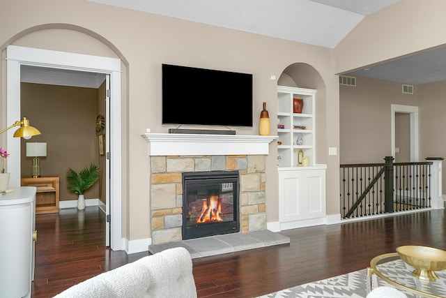 living area with baseboards, visible vents, and wood finished floors