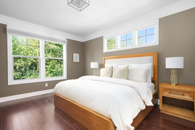 bedroom featuring crown molding, dark wood-style flooring, baseboards, and visible vents