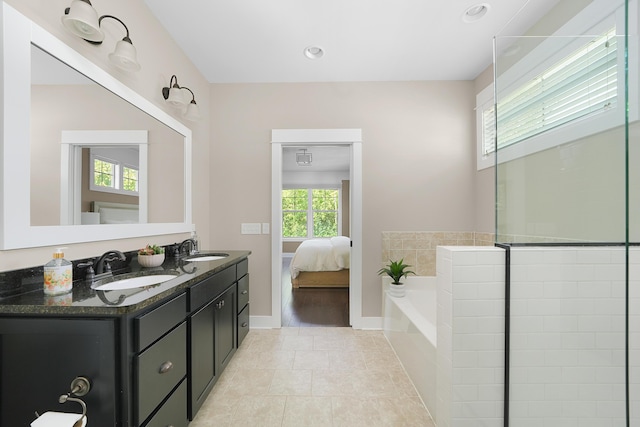 full bathroom with a sink, double vanity, ensuite bath, and a bath