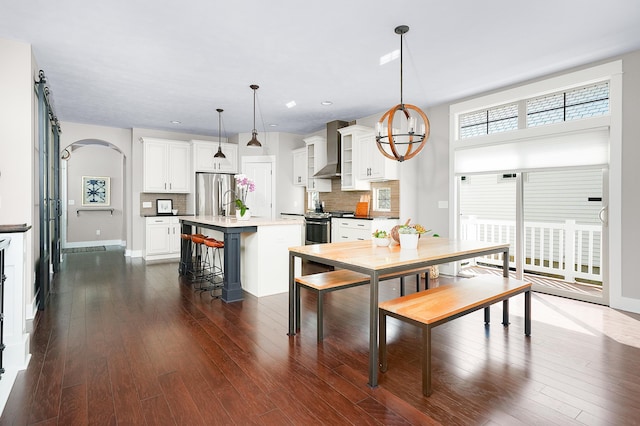 dining room featuring recessed lighting, arched walkways, baseboards, and dark wood-style flooring