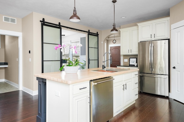 kitchen with a sink, light countertops, stainless steel appliances, and dark wood-style flooring