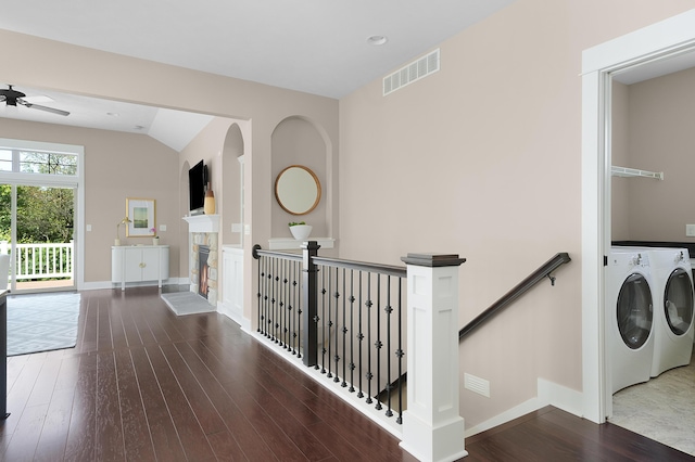 interior space featuring visible vents, wood finished floors, baseboards, an upstairs landing, and washer and clothes dryer