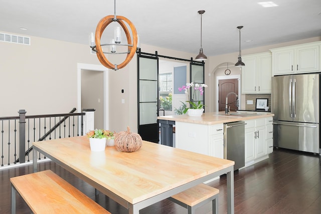 kitchen with visible vents, a sink, light countertops, dark wood-style floors, and stainless steel appliances