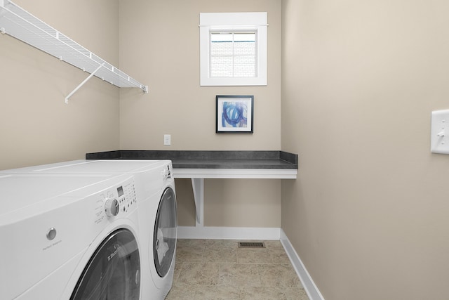 clothes washing area featuring separate washer and dryer, baseboards, laundry area, and visible vents