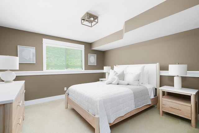 bedroom with light colored carpet and baseboards