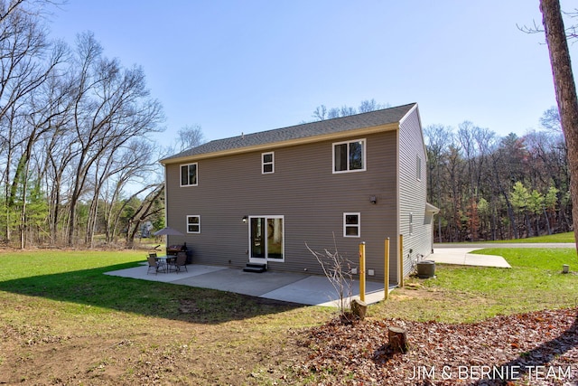 back of property with a lawn, a patio area, and central AC