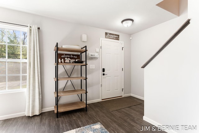foyer entrance with dark wood-type flooring and baseboards