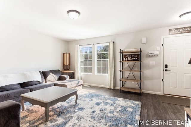 living room featuring dark wood-type flooring and baseboards