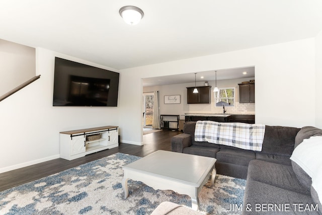 living area featuring baseboards and dark wood-style flooring