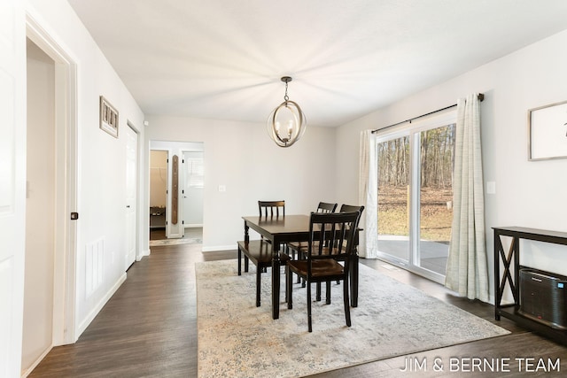 dining room with baseboards, a chandelier, and dark wood finished floors