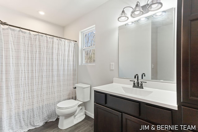 bathroom featuring wood finished floors, toilet, and vanity