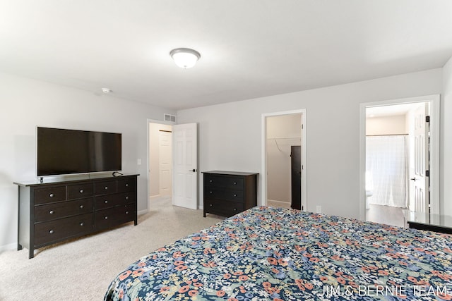 bedroom with a spacious closet, baseboards, visible vents, and carpet floors