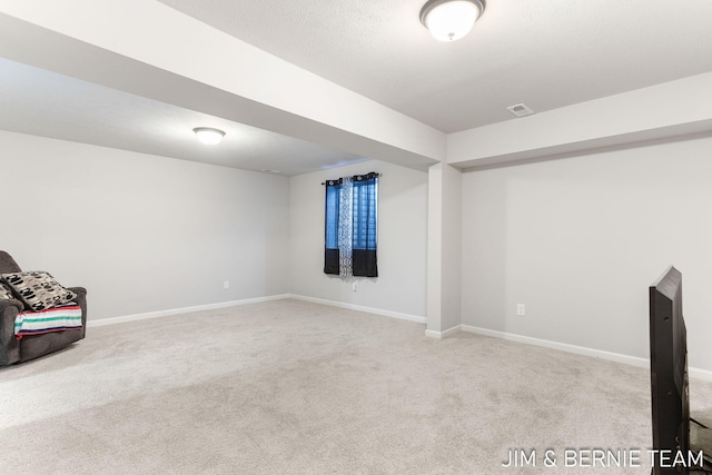 unfurnished room with carpet, visible vents, and baseboards