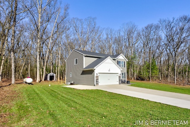 view of side of home with an attached garage, driveway, and a yard