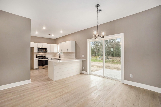 3574 Valley View Dr, Muskegon, MI 49444 - kitchen with stainless steel appliances, baseboards, a sink, a chandelier, and light countertops