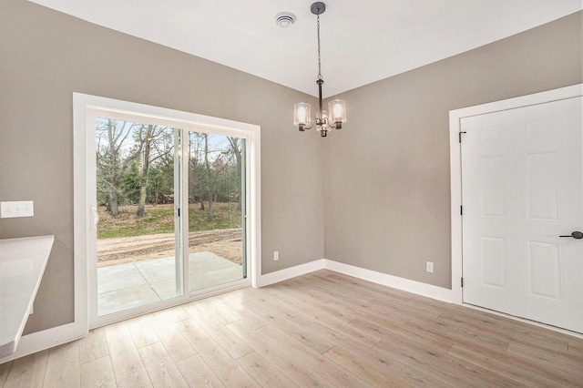 3574 Valley View Dr, Muskegon, MI 49444 - unfurnished dining area with baseboards, a chandelier, and light wood-style flooring