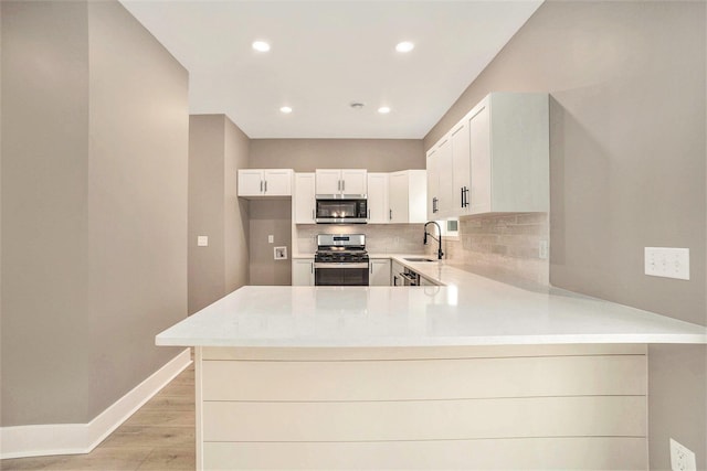 3574 Valley View Dr, Muskegon, MI 49444 - kitchen with appliances with stainless steel finishes, a sink, backsplash, light countertops, and recessed lighting