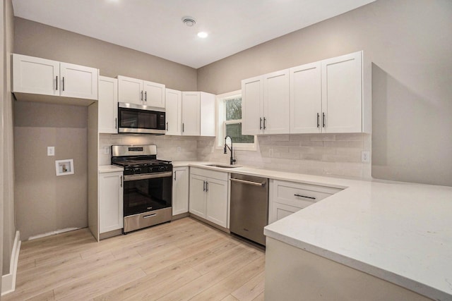 3574 Valley View Dr, Muskegon, MI 49444 - kitchen with appliances with stainless steel finishes, a sink, light countertops, light wood-style floors, and recessed lighting