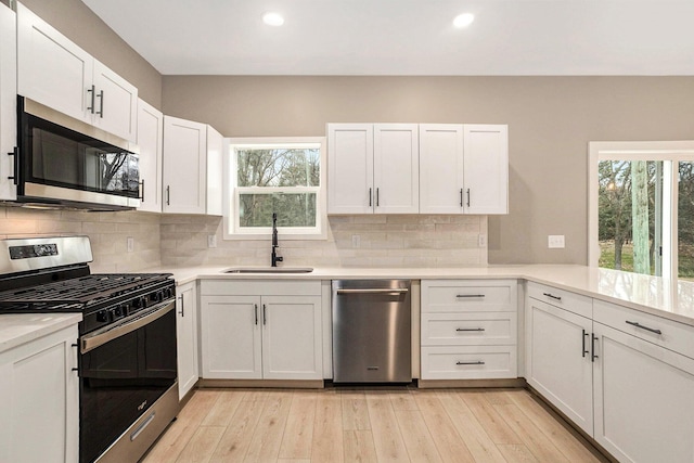 3574 Valley View Dr, Muskegon, MI 49444 - kitchen featuring appliances with stainless steel finishes, a sink, recessed lighting, light countertops, and backsplash