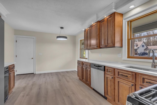 9315 Kingsley Dr, Onsted, MI 49265 - kitchen featuring stainless steel dishwasher, brown cabinetry, light wood-style floors, plenty of natural light, and a textured ceiling
