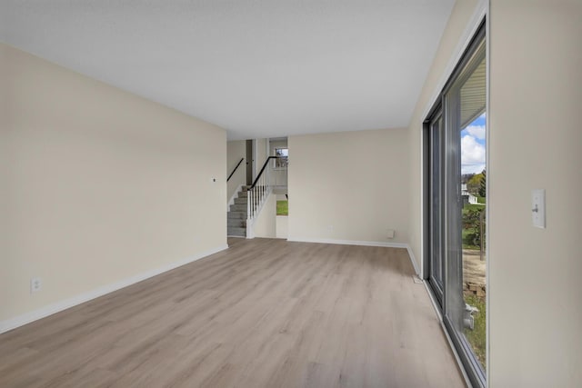 9315 Kingsley Dr, Onsted, MI 49265 - unfurnished living room featuring light wood finished floors, stairs, and baseboards