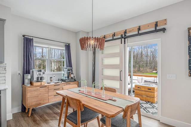 2537 Odawa Trl, Muskegon, MI 49444 - dining space featuring baseboards, light wood-style floors, and a barn door