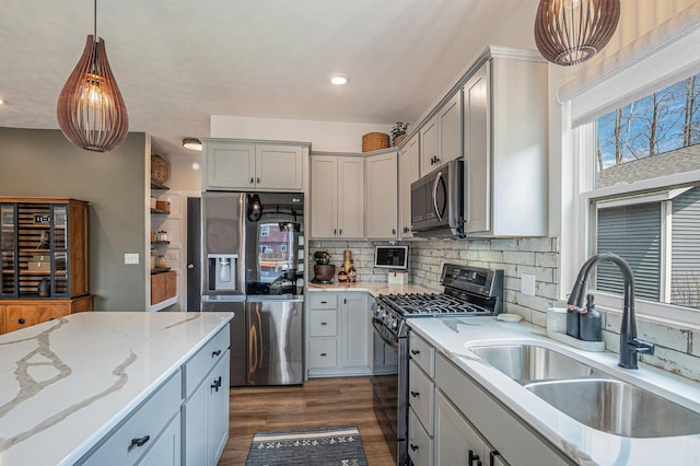 2537 Odawa Trl, Muskegon, MI 49444 - kitchen featuring stainless steel appliances, a sink, tasteful backsplash, dark wood-type flooring, and hanging light fixtures
