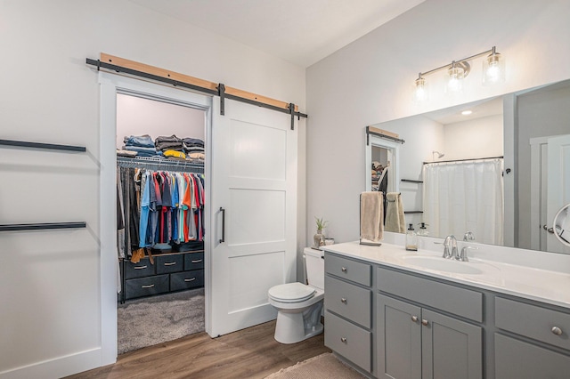 2537 Odawa Trl, Muskegon, MI 49444 - bathroom featuring wood finished floors, a walk in closet, vanity, a shower with curtain, and toilet