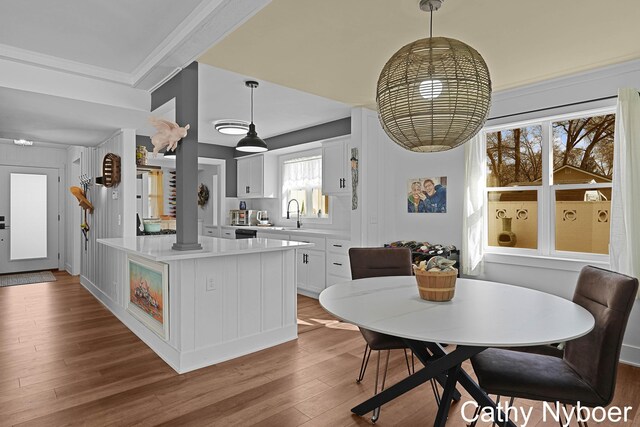 2233 Mills Ave, Muskegon, MI 49445 - kitchen featuring a kitchen island, pendant lighting, wood finished floors, light countertops, and white cabinetry