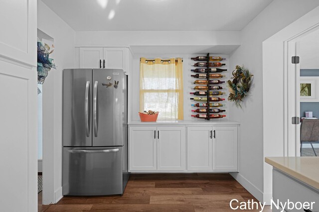 2233 Mills Ave, Muskegon, MI 49445 - kitchen featuring freestanding refrigerator, dark wood-style flooring, baseboards, light countertops, and white cabinetry
