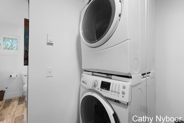 2233 Mills Ave, Muskegon, MI 49445 - washroom with baseboards, stacked washer / drying machine, light wood-style flooring, and laundry area