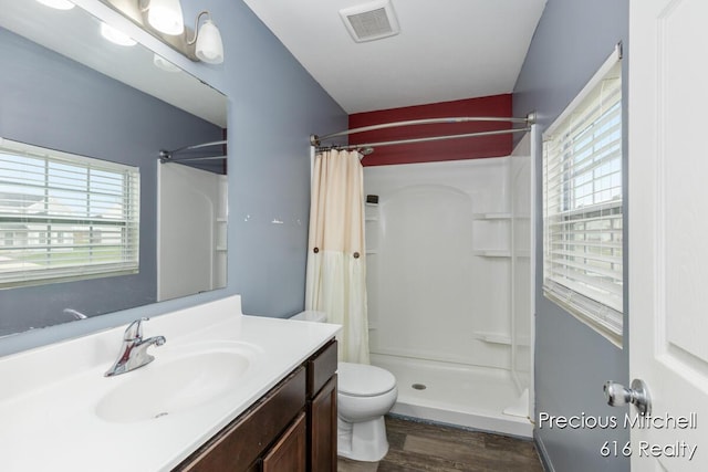 full bathroom with a shower with curtain, wood finished floors, visible vents, and plenty of natural light