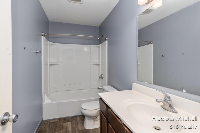 bathroom with toilet, vanity, wood finished floors, and visible vents